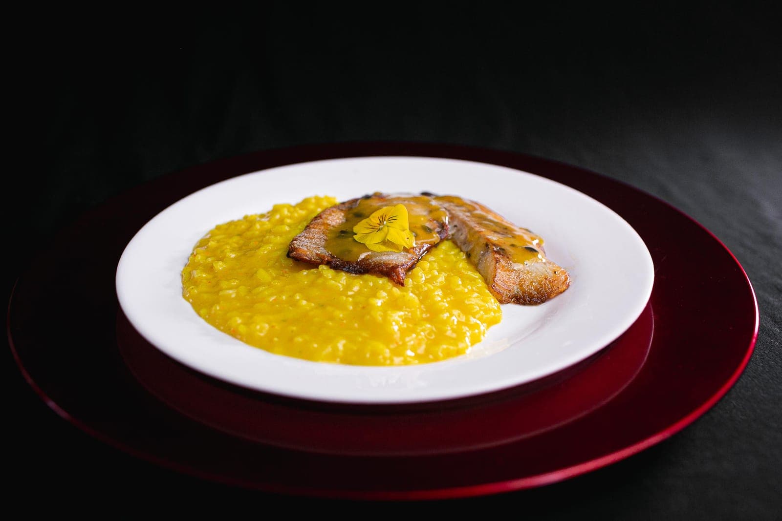 Filé de peixe grelhado ao molho de maracujá sobre risoto de açafrão